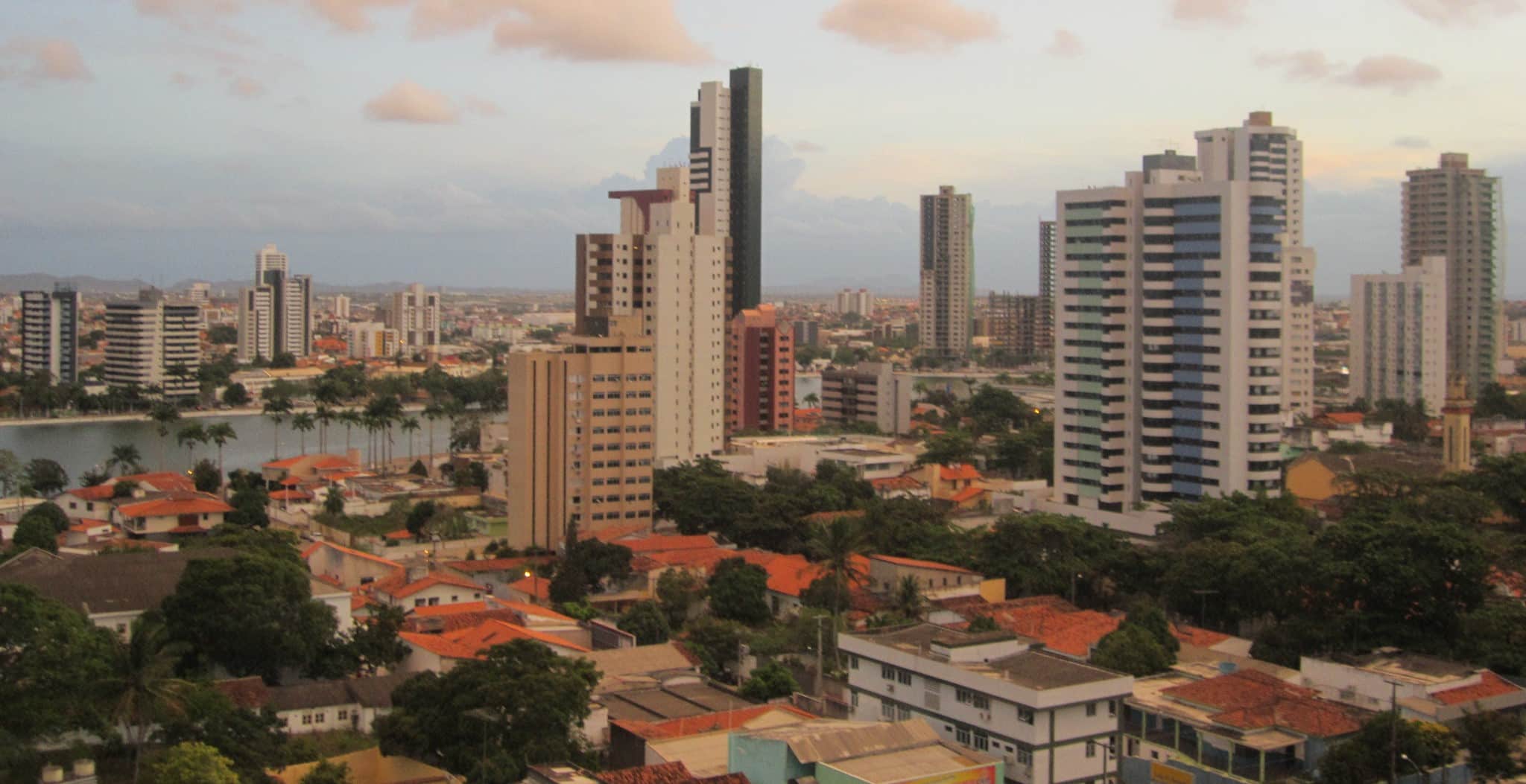 A city with scattered trees and a river running through the center-left.