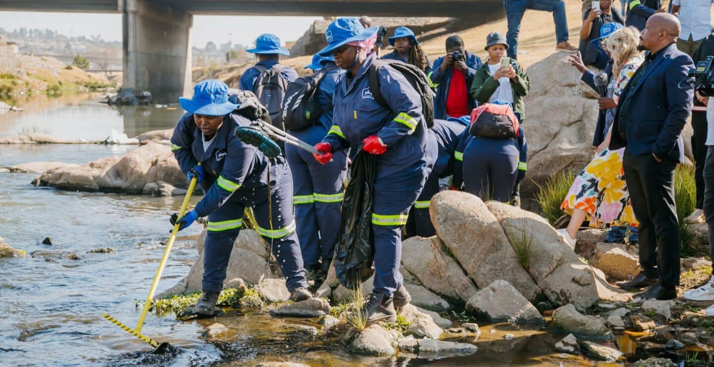 A group of people removing trash from a river.